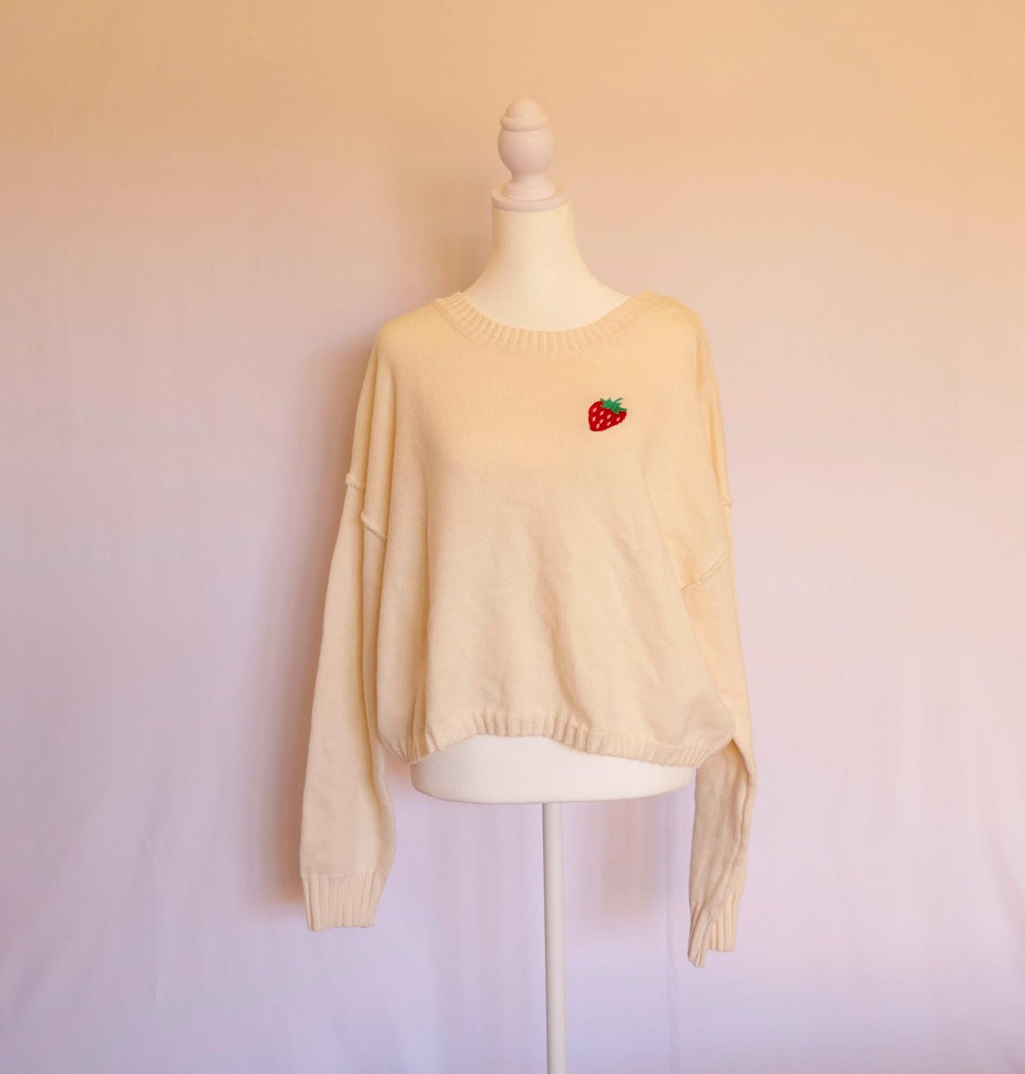 Suéter manga larga crema con fresa